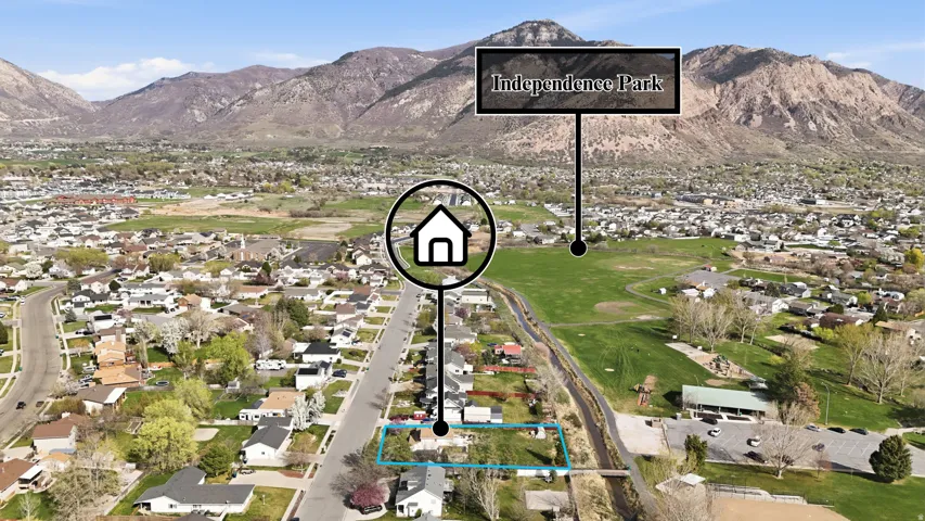 Aerial view of residential area featuring property boundaries highlighted and a mountainous background
