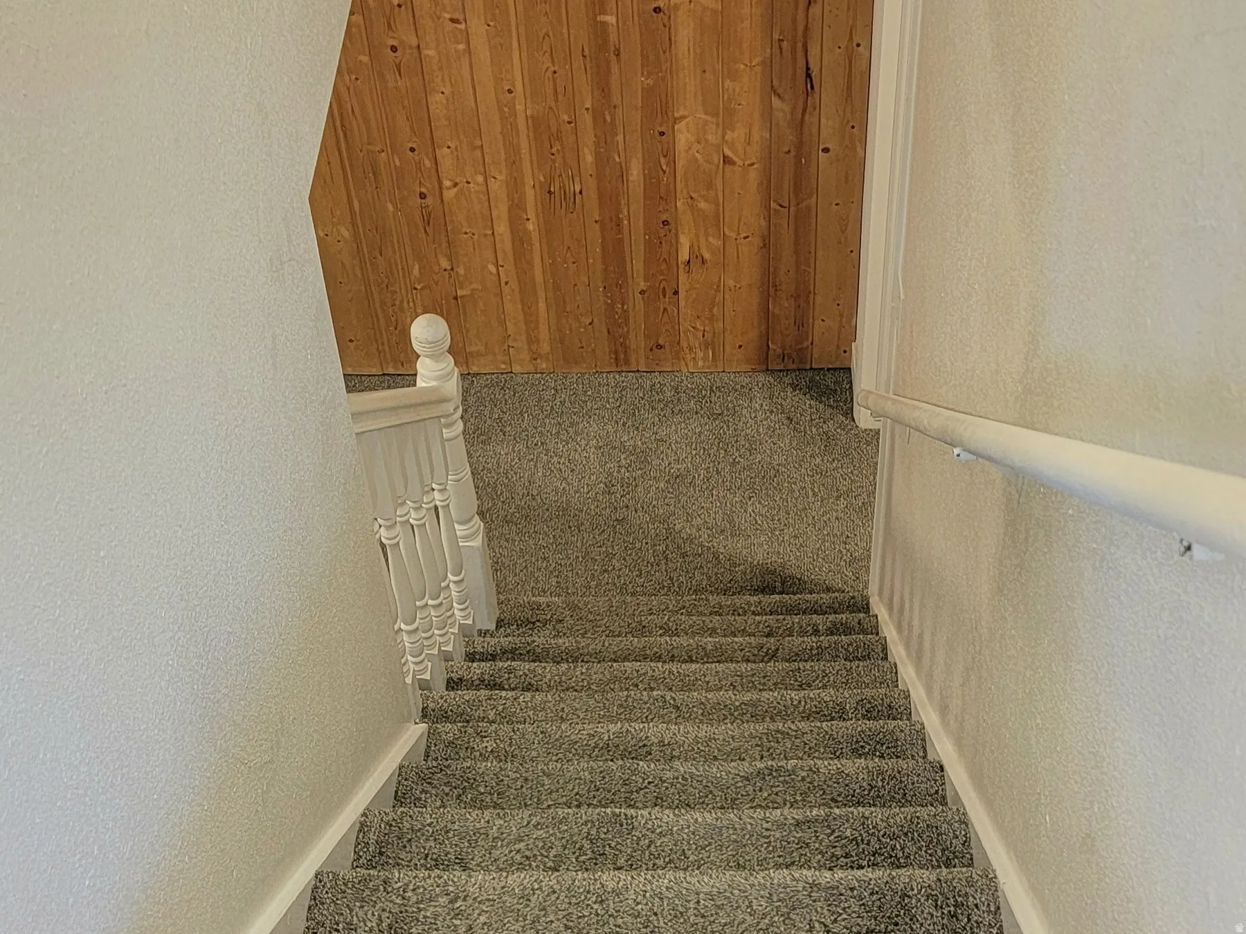 Stairs with wooden walls and a textured wall