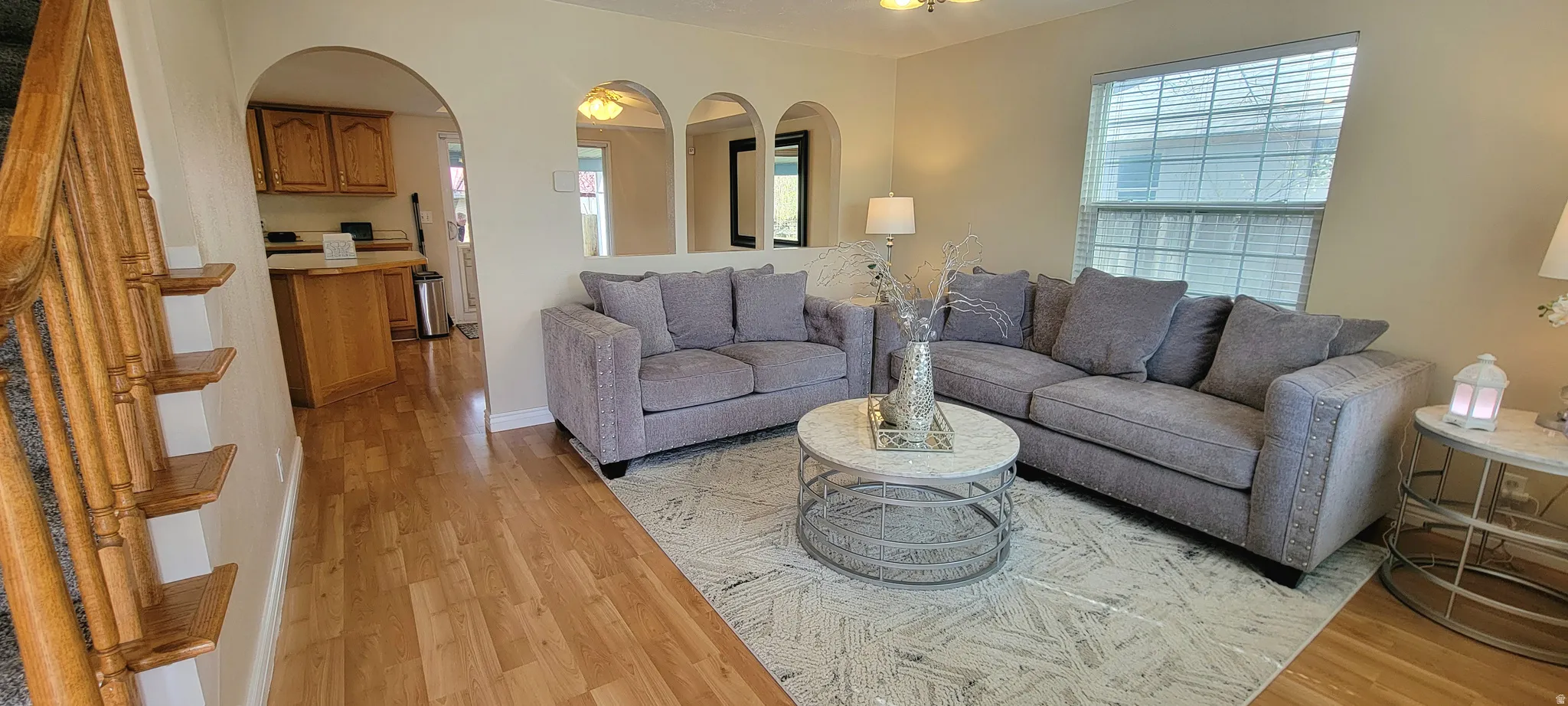 Living area featuring light wood-style floors and arched walkways