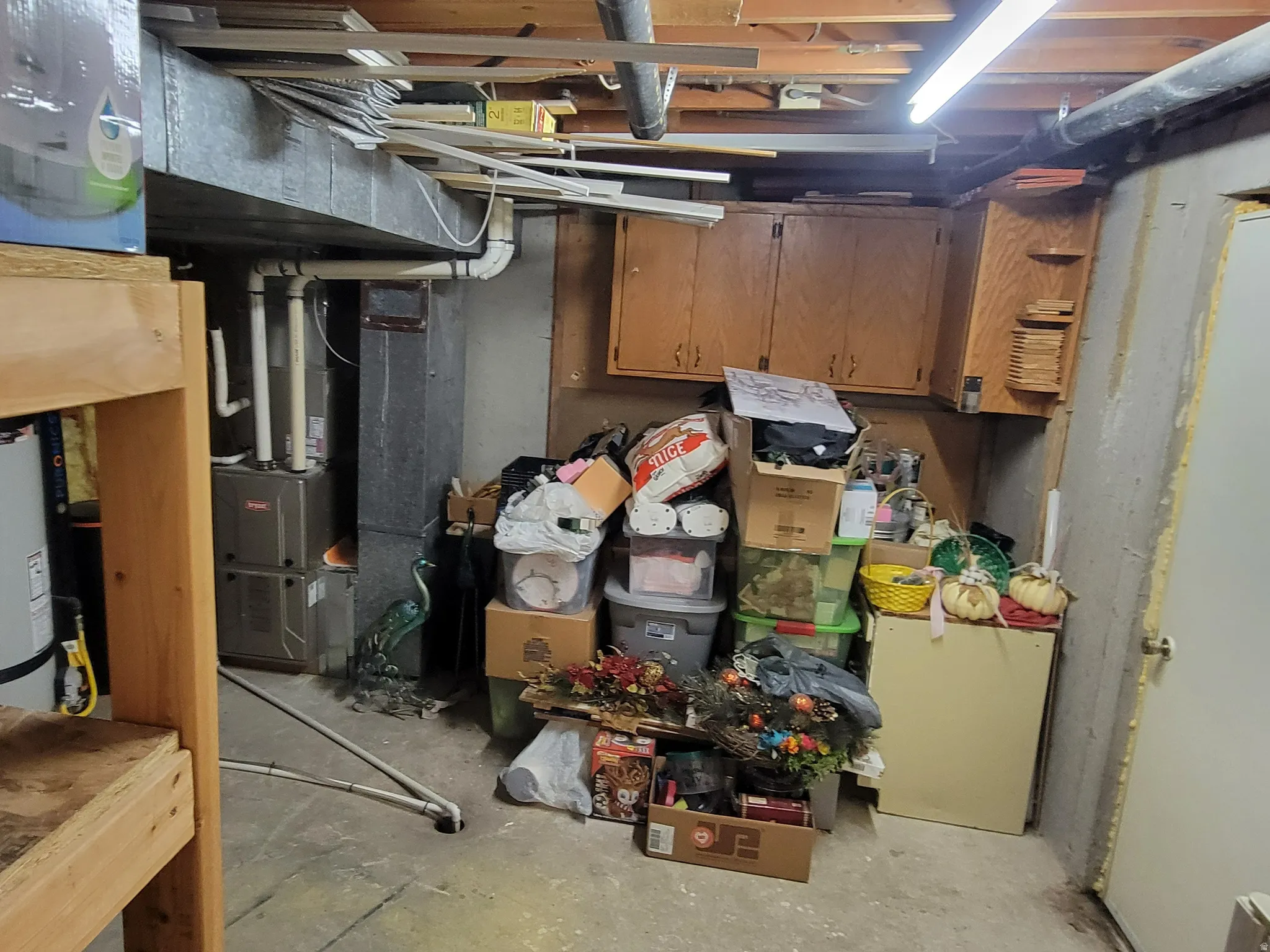 Unfinished basement featuring water heater and heating unit