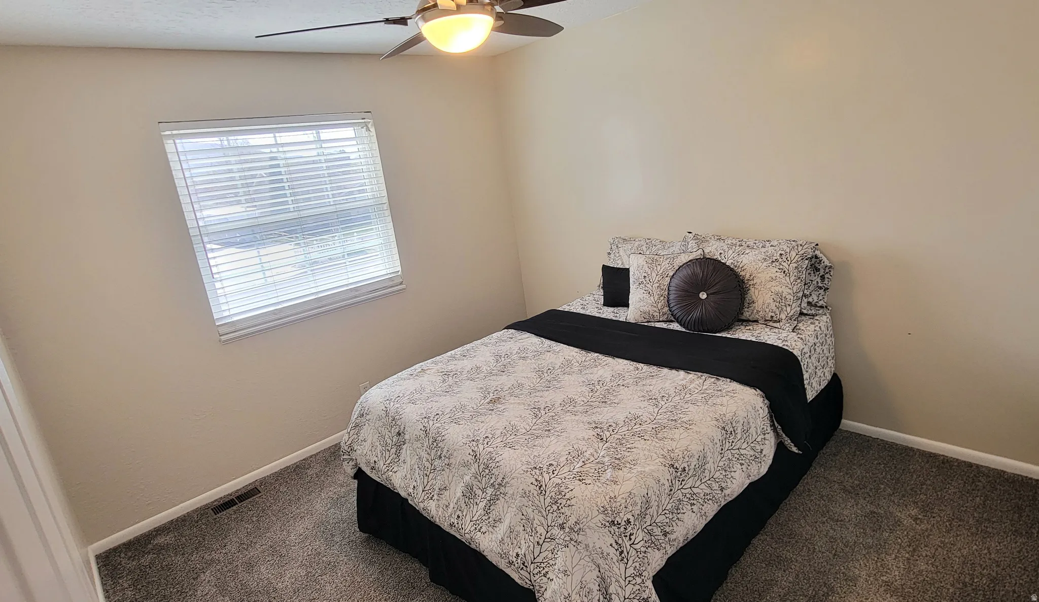 Bedroom featuring ceiling fan and dark carpet