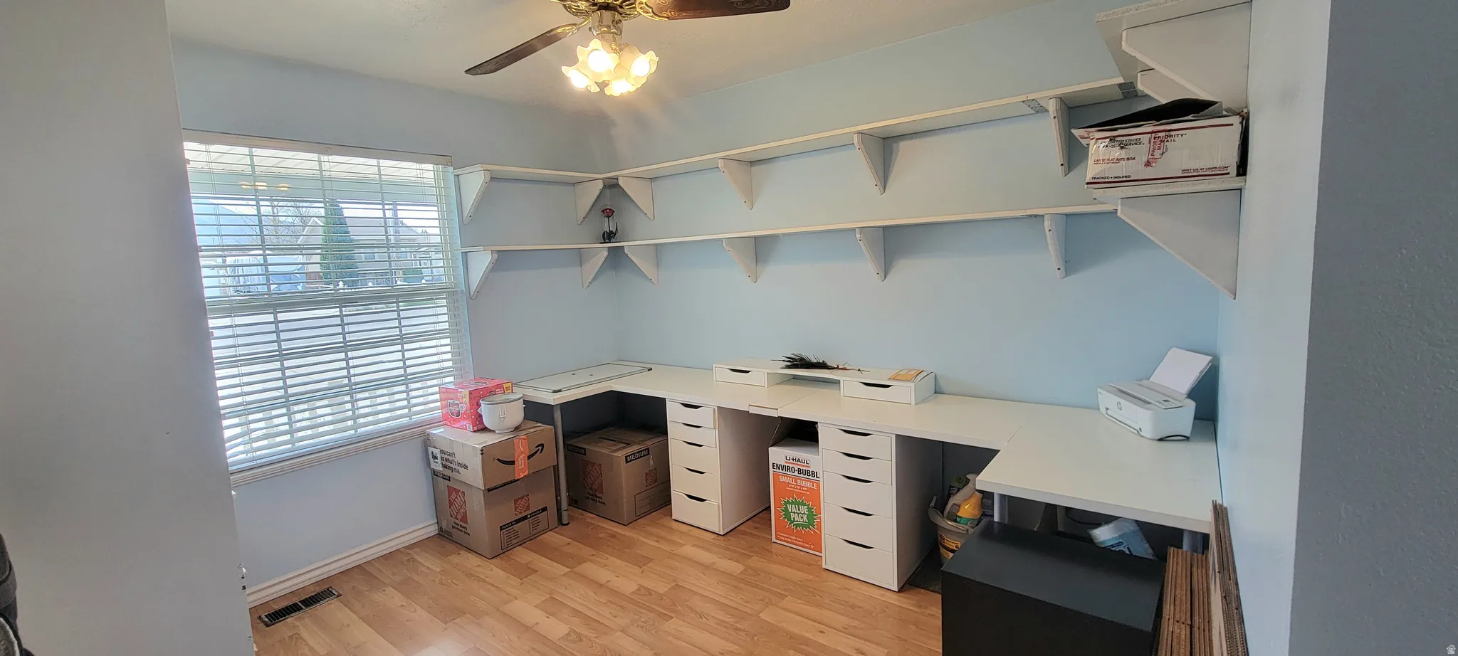 Unfurnished office with ceiling fan and light wood-style floors