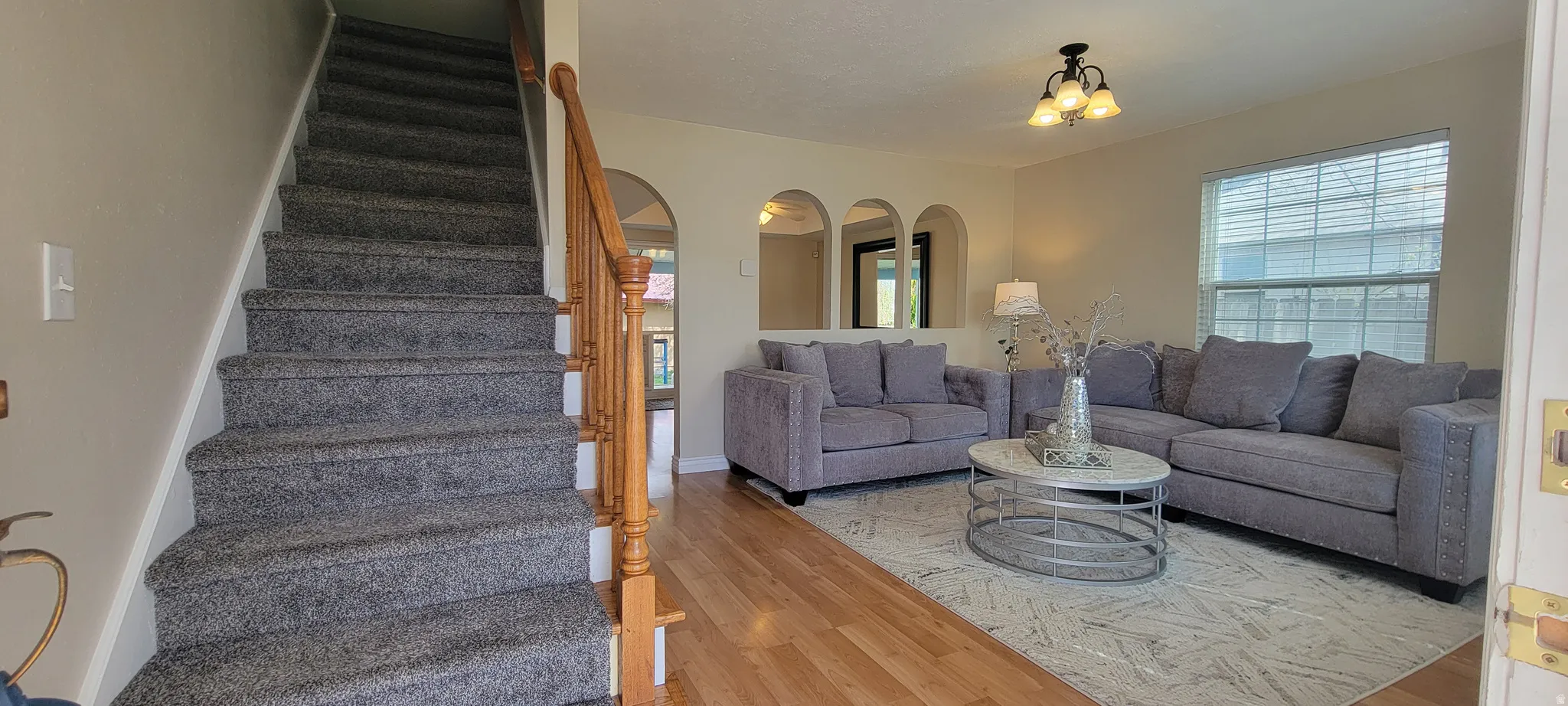 Living area with arched walkways and light wood-type flooring