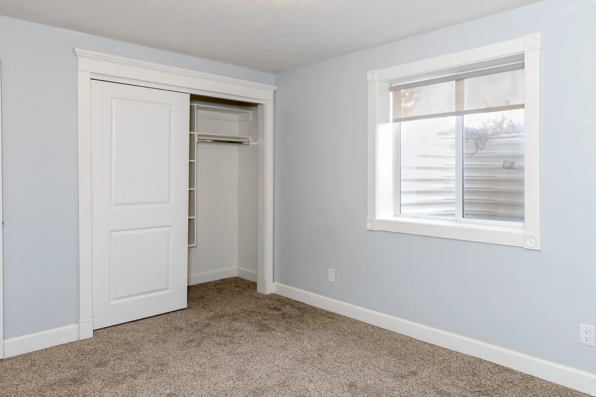 Unfurnished bedroom featuring a closet and light carpet