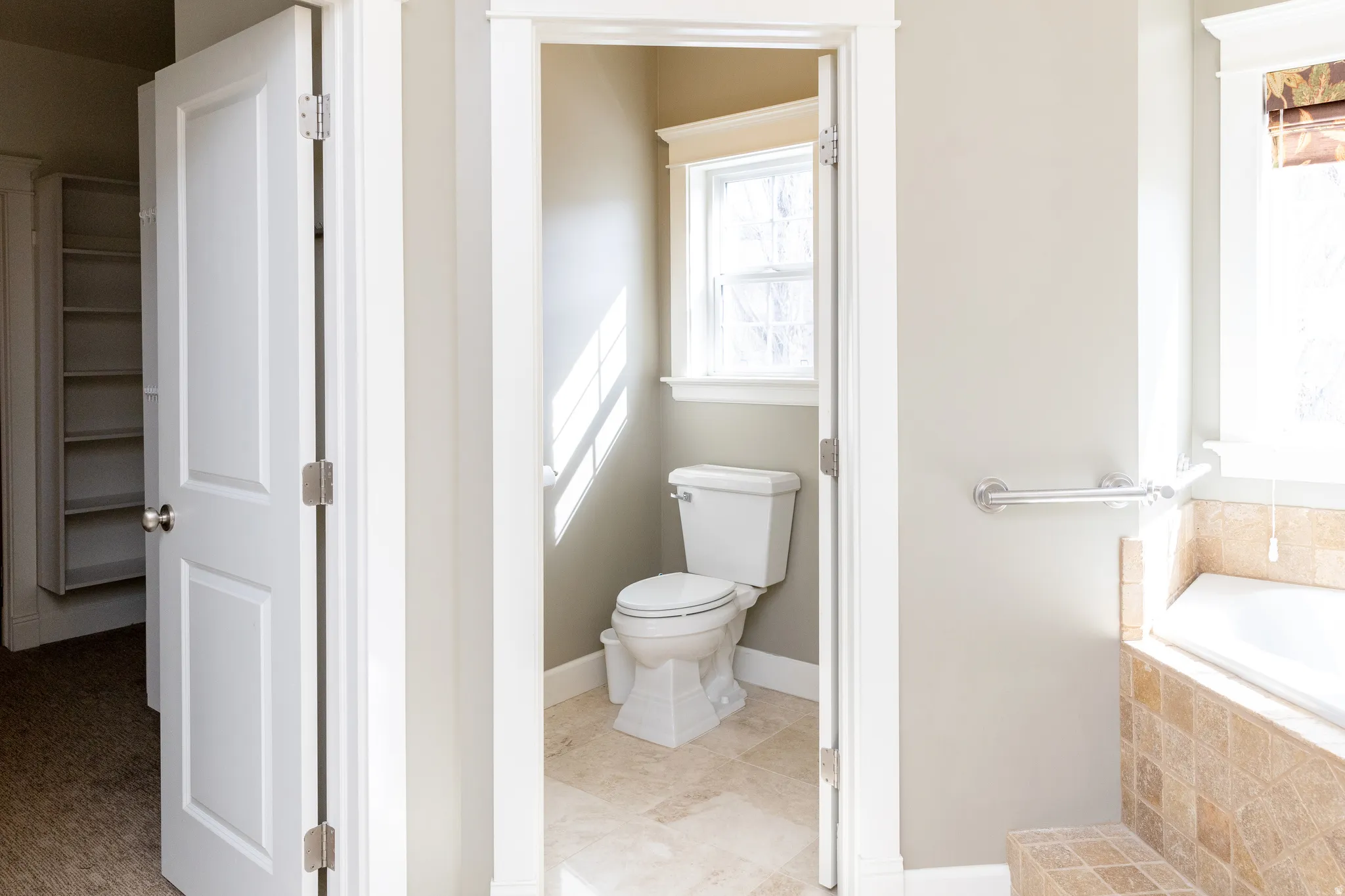 Bathroom featuring a garden tub and toilet