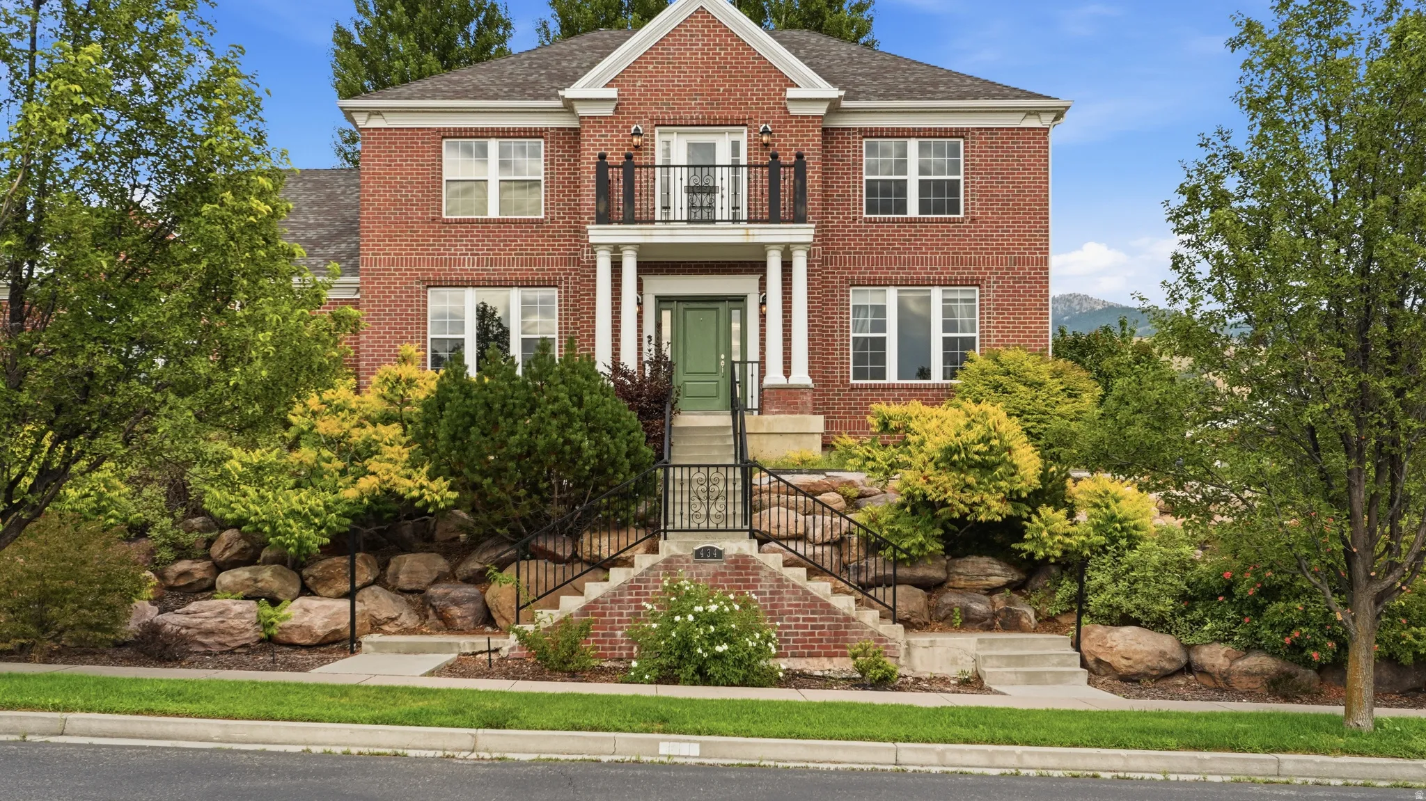 Traditional brick exterior with white trim windows and a green entry door