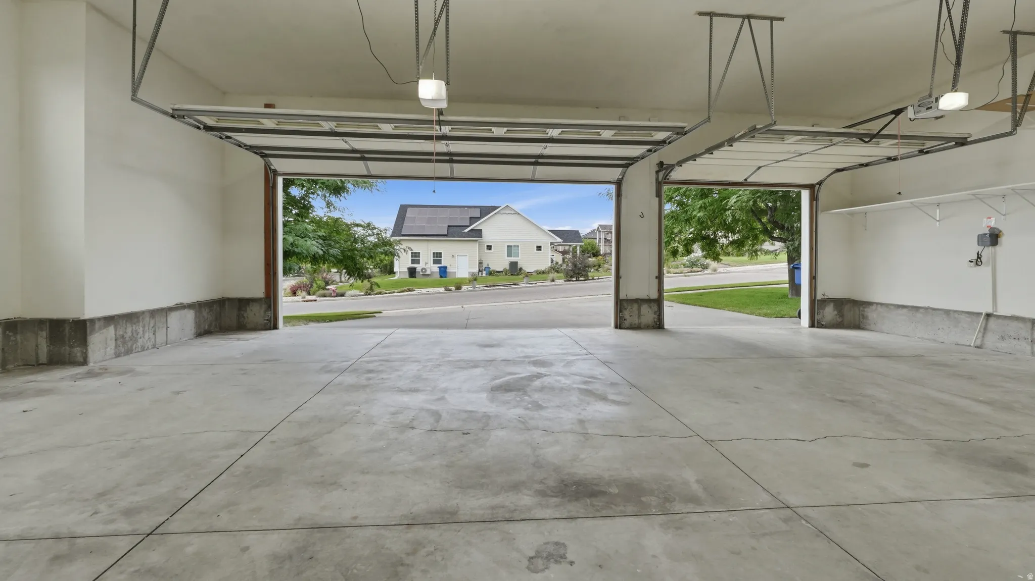 Expansive garage featuring concrete flooring and two overhead garage doors