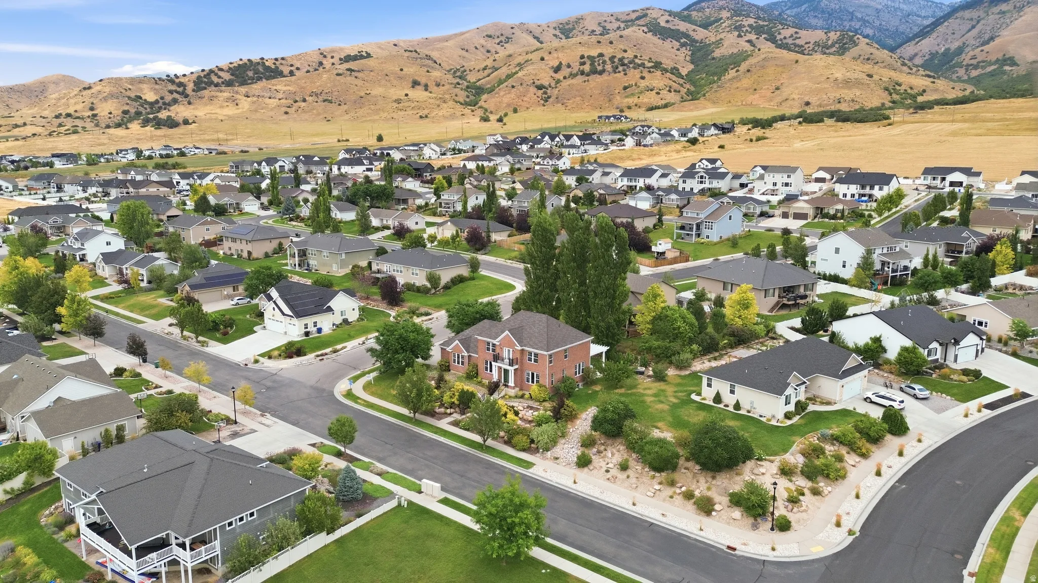 Residential neighborhood with mature landscaping and mountain backdrop