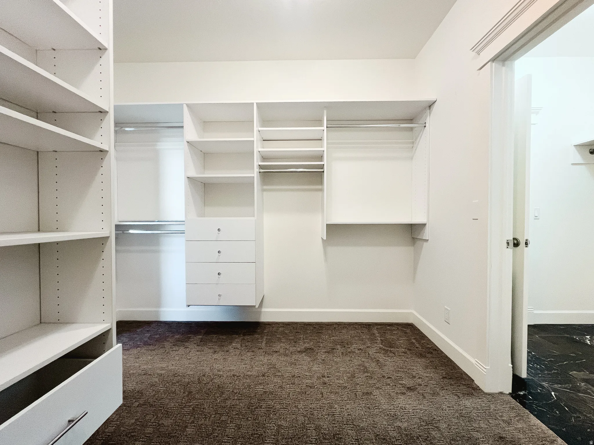 Walk in closet with entrance to laundry room