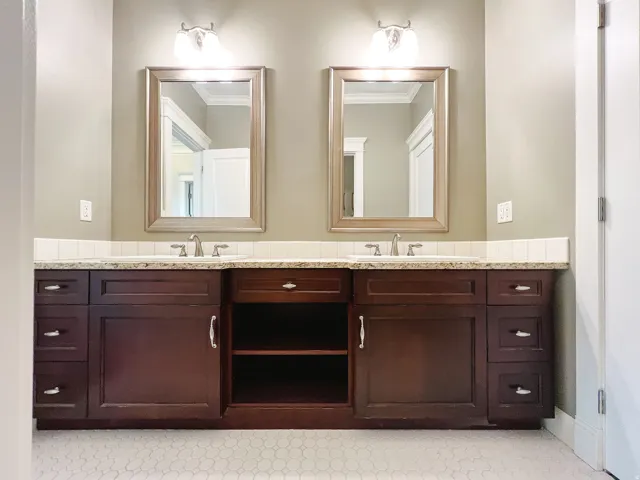 Full bath featuring double vanity and ornamental molding