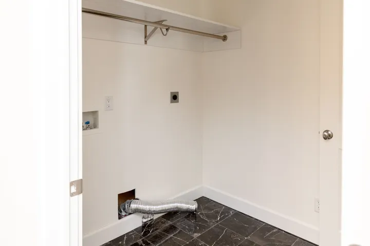 Laundry area with dark marble finish- enter from both hallway and master closet
