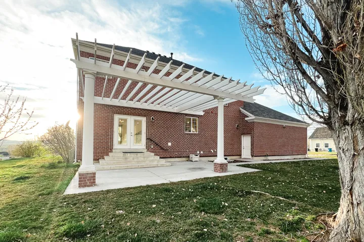 Back of property featuring a yard, a patio area, brick siding, and entry steps