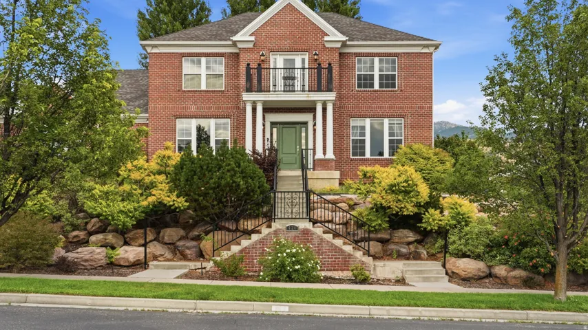 Traditional brick exterior with white trim windows and a green entry door