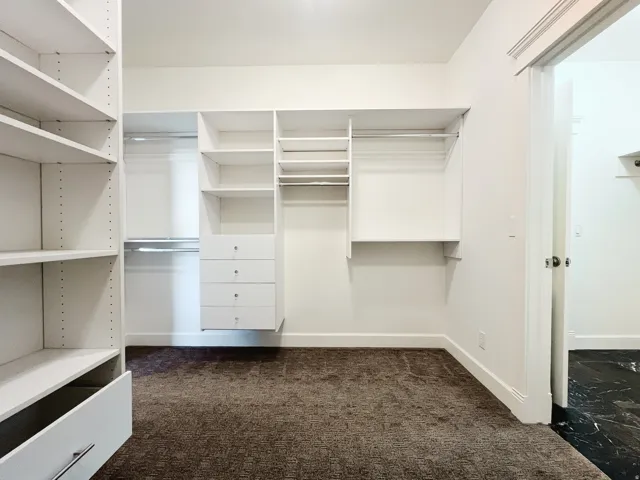 Walk in closet with entrance to laundry room
