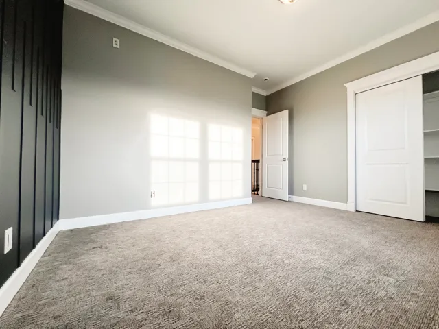 bedroom featuring carpet floors, crown molding, and a closet