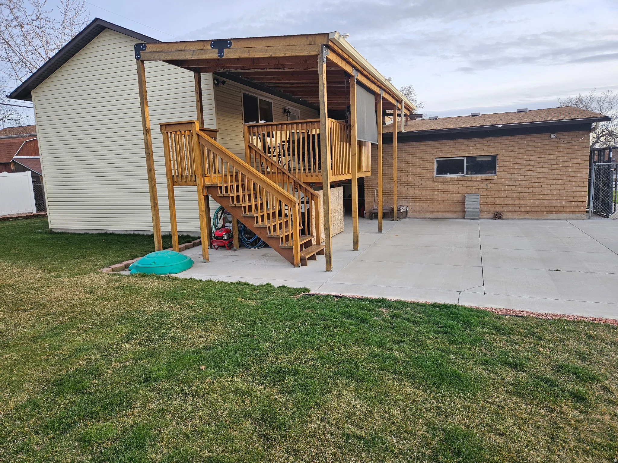 Rear view of property featuring a patio area, a deck, and brick siding