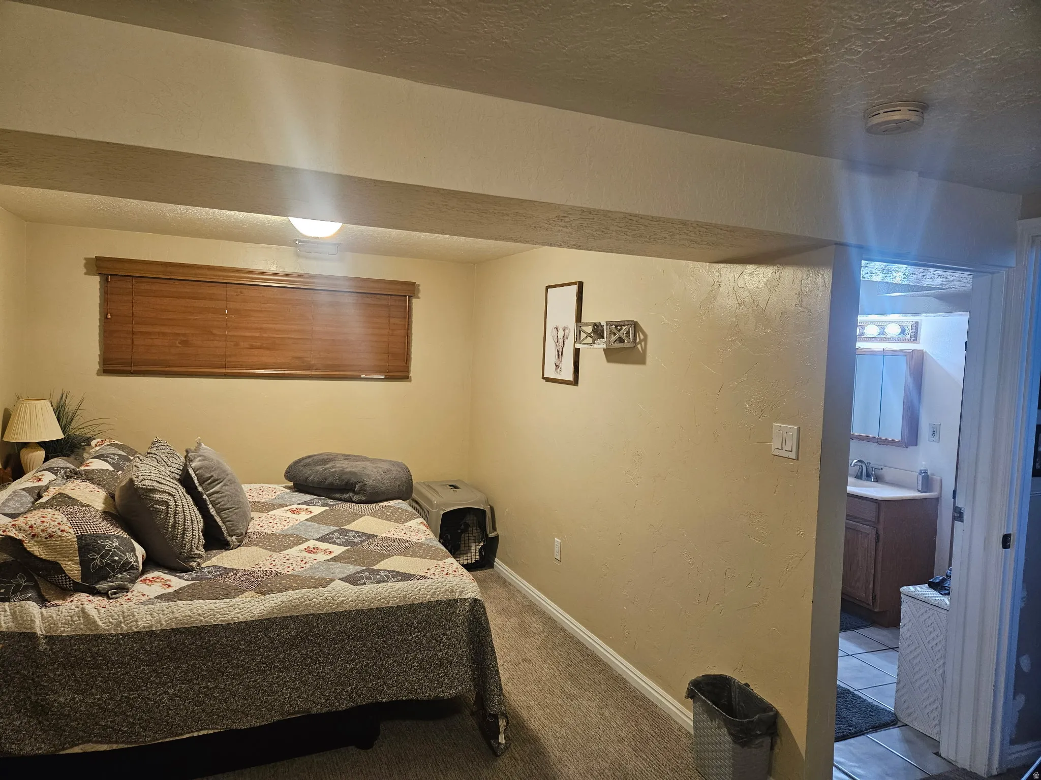 Carpeted bedroom featuring a textured wall and a textured ceiling