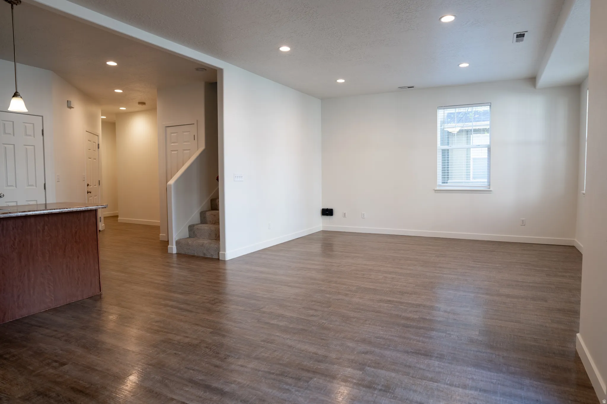 Unfurnished living room featuring recessed lighting, dark wood finished floors, and a textured ceiling