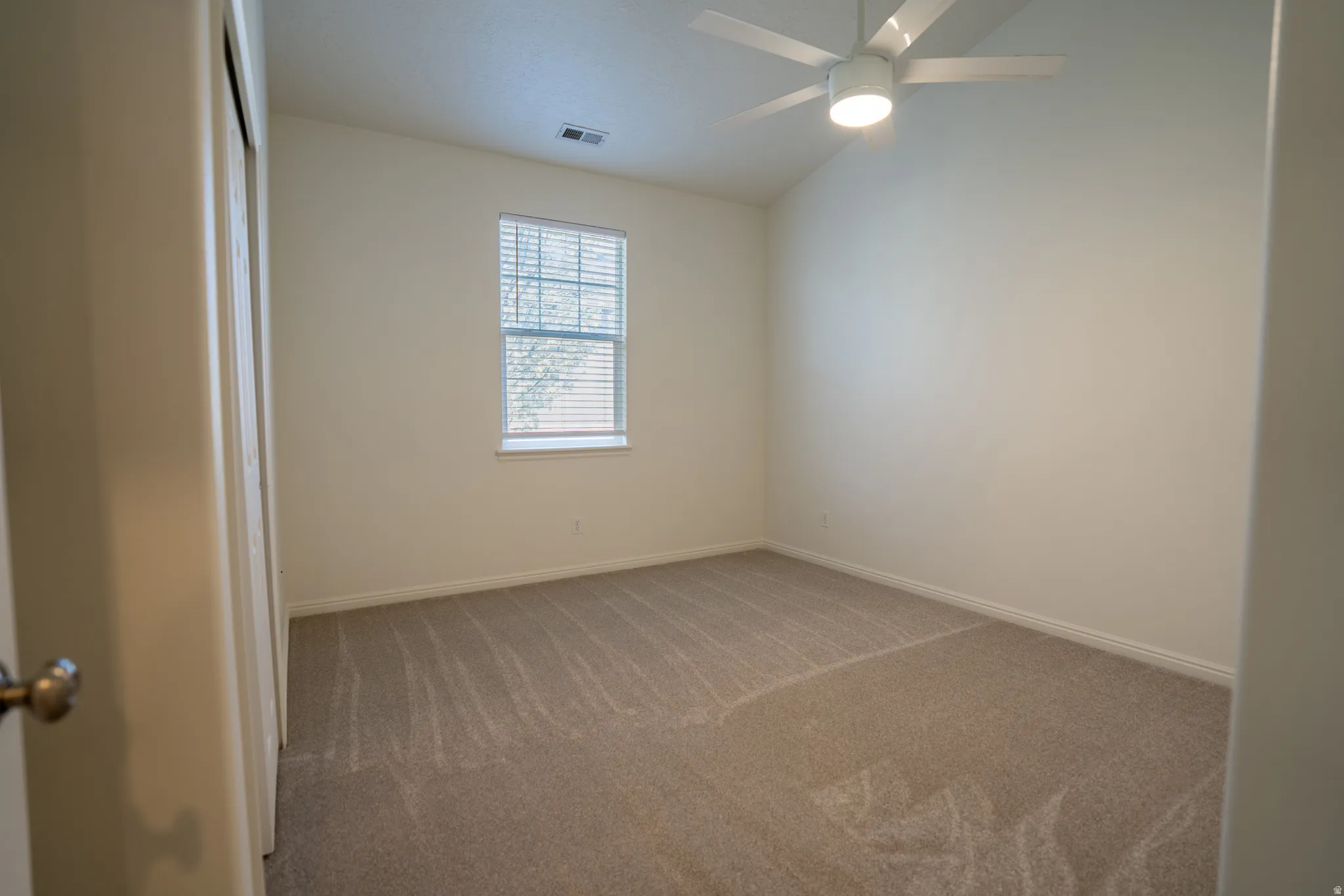 Spare room with carpet, lofted ceiling, and ceiling fan