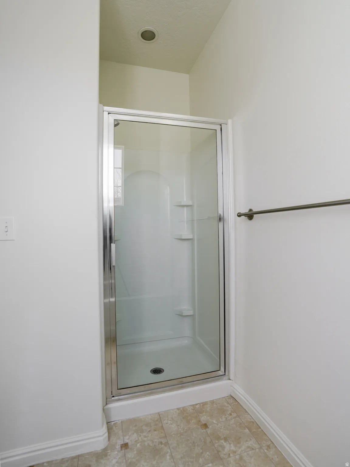 Full bathroom with a shower stall and light tile patterned floors