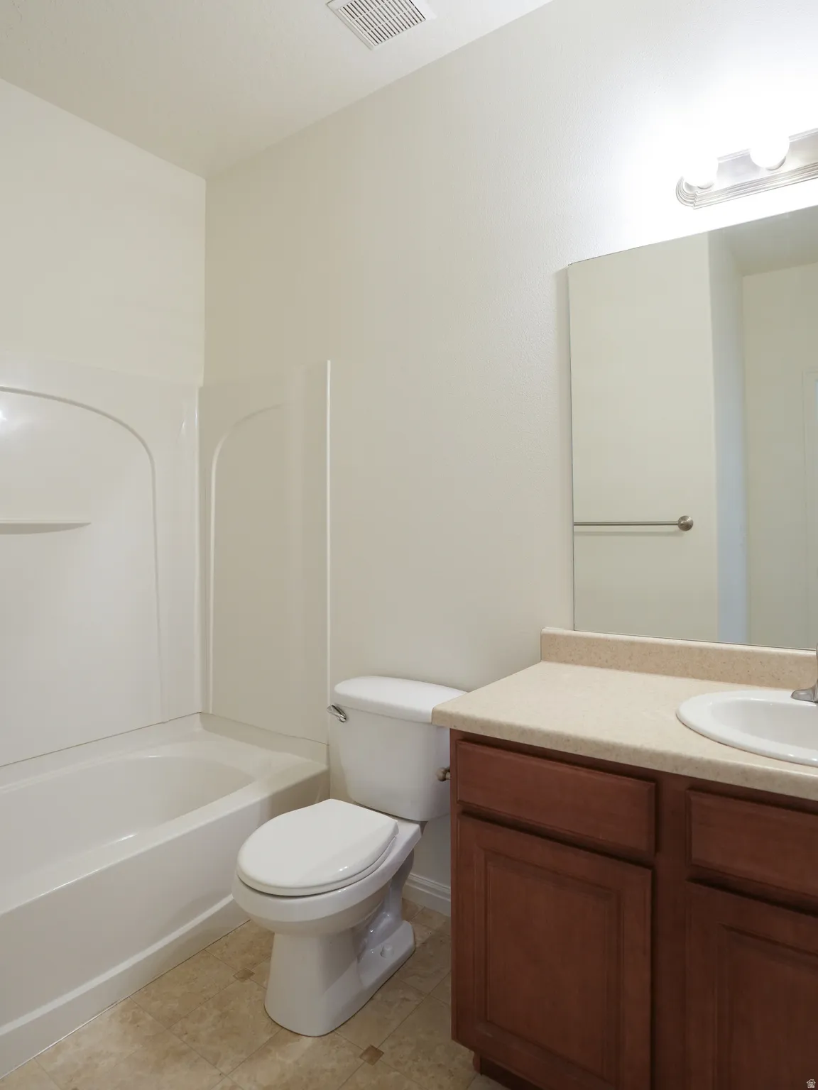Full bathroom featuring vanity, washtub / shower combination, and light tile patterned floors