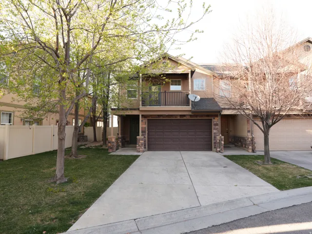 Craftsman house with a balcony, stone siding, concrete driveway, and an attached garage
