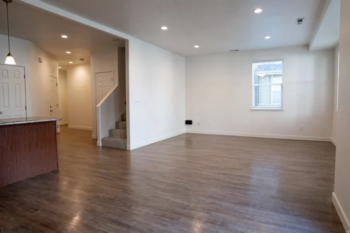Unfurnished living room featuring recessed lighting, dark wood finished floors, and a textured ceiling