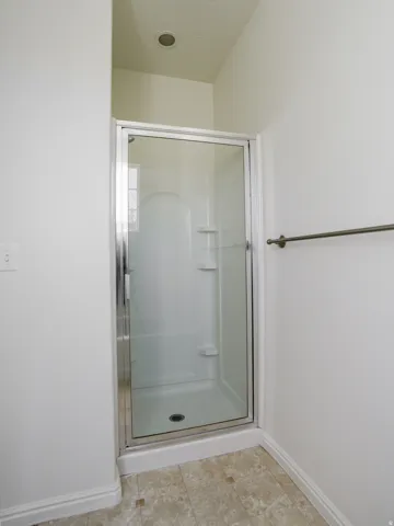 Full bathroom with a shower stall and light tile patterned floors