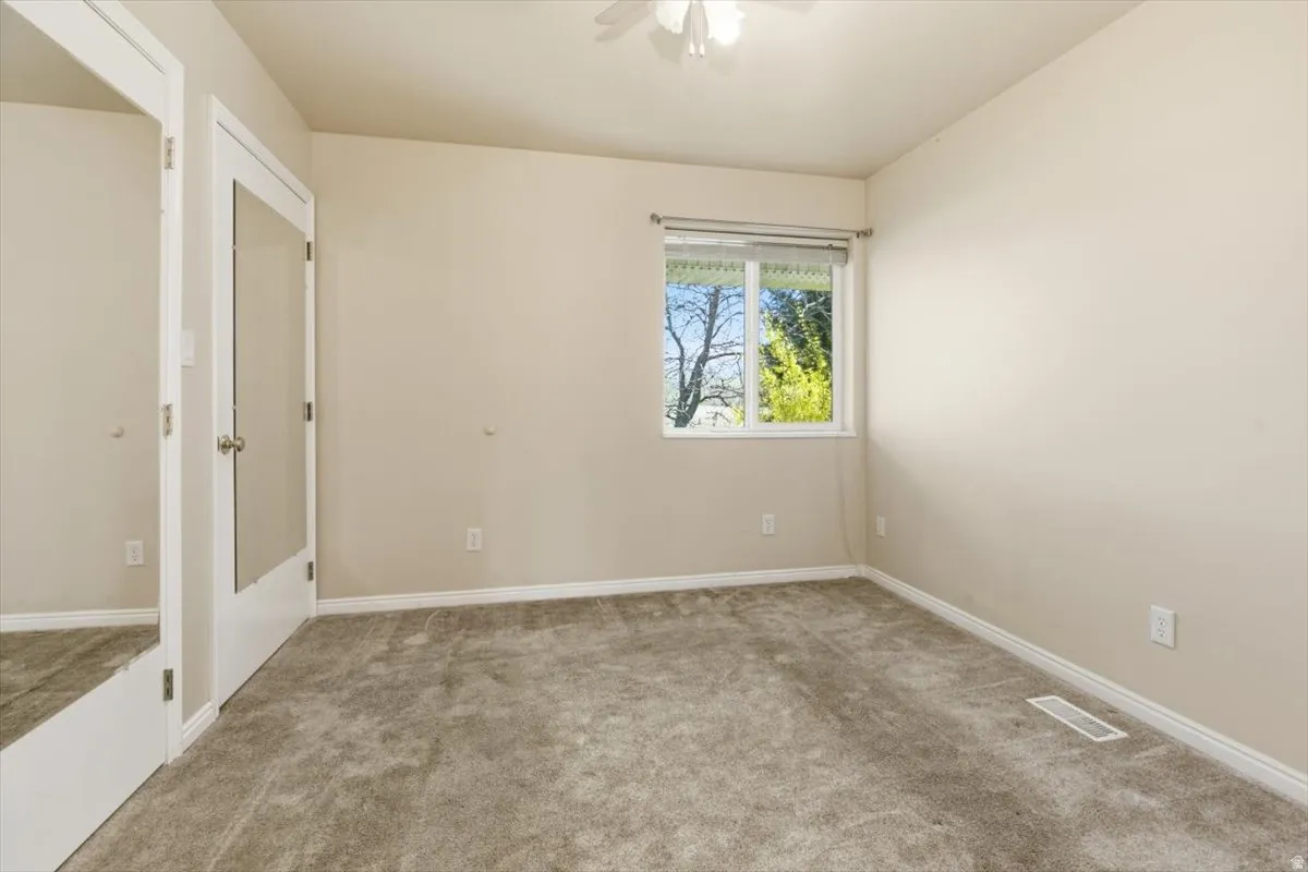 Unfurnished bedroom featuring carpet floors and ceiling fan