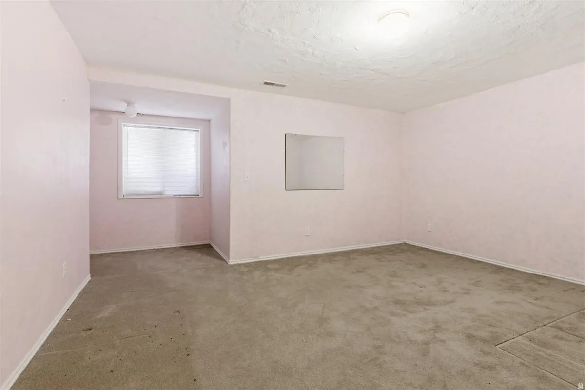 Spare room featuring light carpet and a textured ceiling