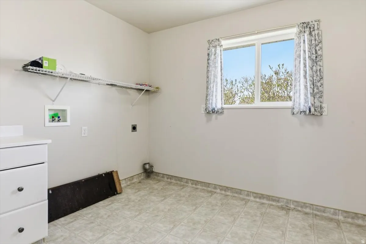 Laundry area with washer hookup, electric dryer hookup, and light flooring
