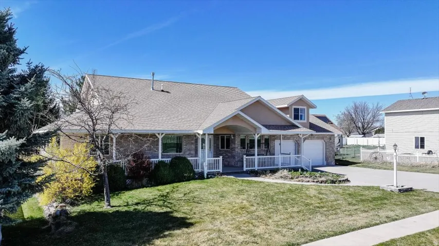 View of front of house featuring a porch, driveway, a garage, and a shingled roof