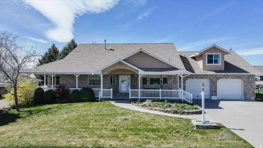 View of front of home featuring a porch, a front yard, concrete driveway, a shingled roof, and a garage