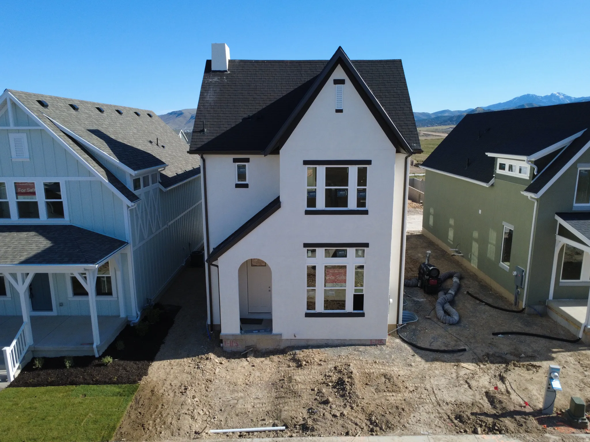 Modern farmhouse-style exterior featuring a white facade and dark trim
