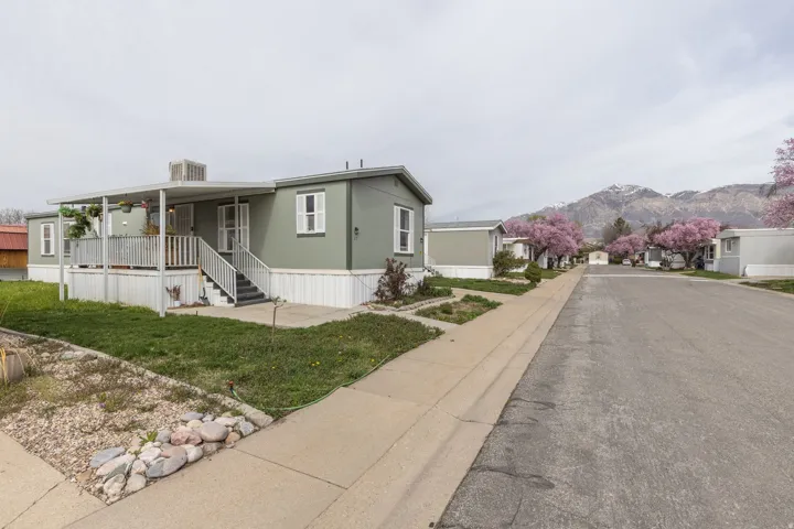 Manufactured / mobile home with a porch, a front lawn, and a mountain view