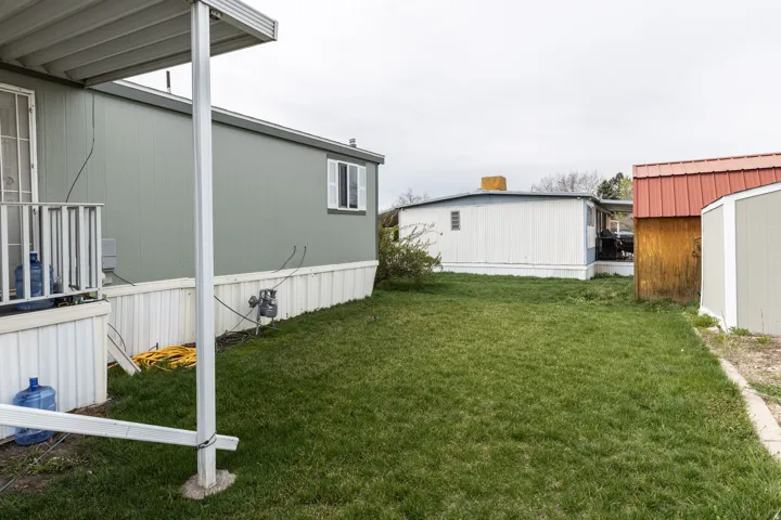 View of green lawn with a storage shed