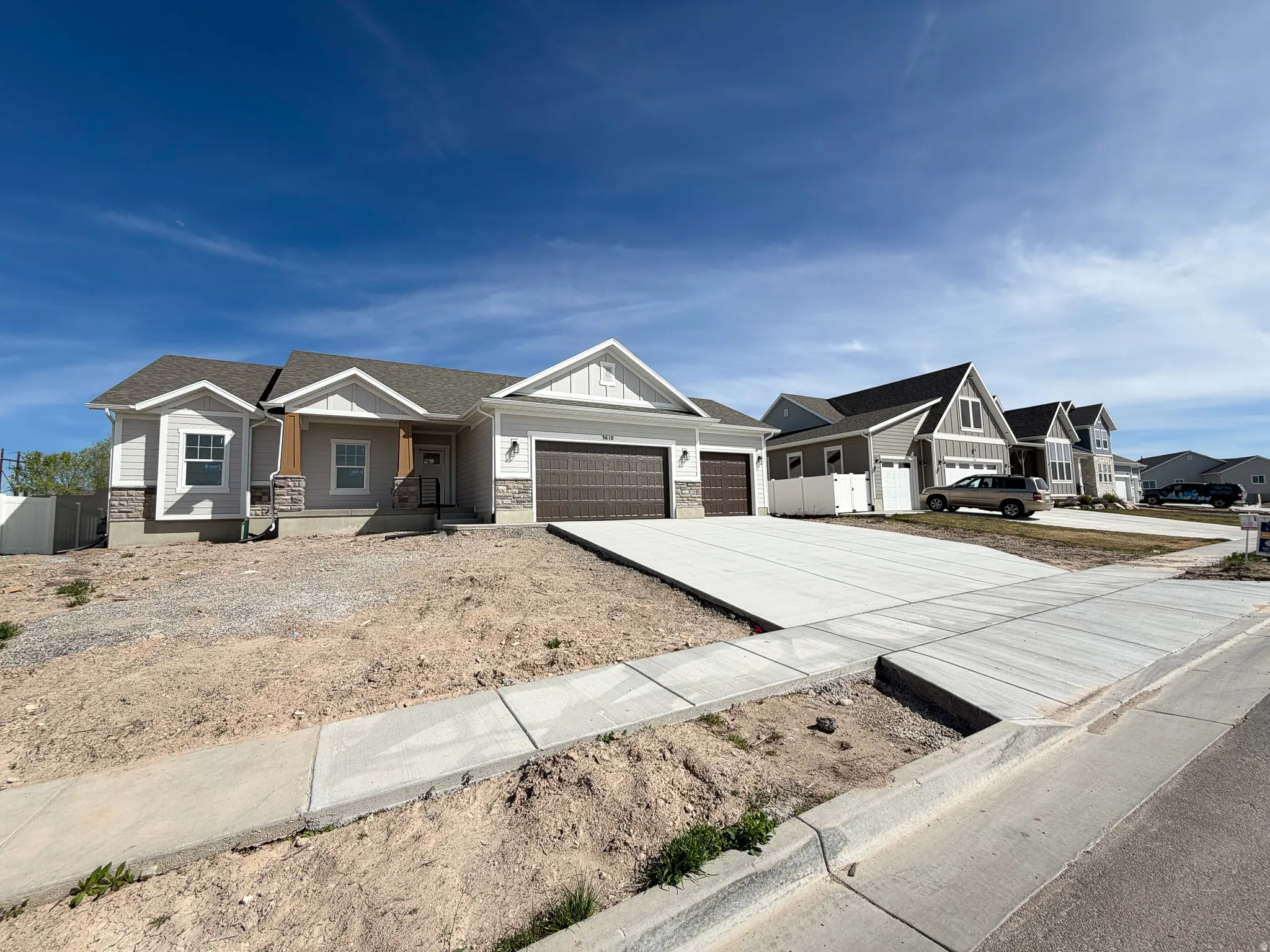 View of front of house featuring a garage, covered porch, concrete driveway, a residential view, and board and batten siding