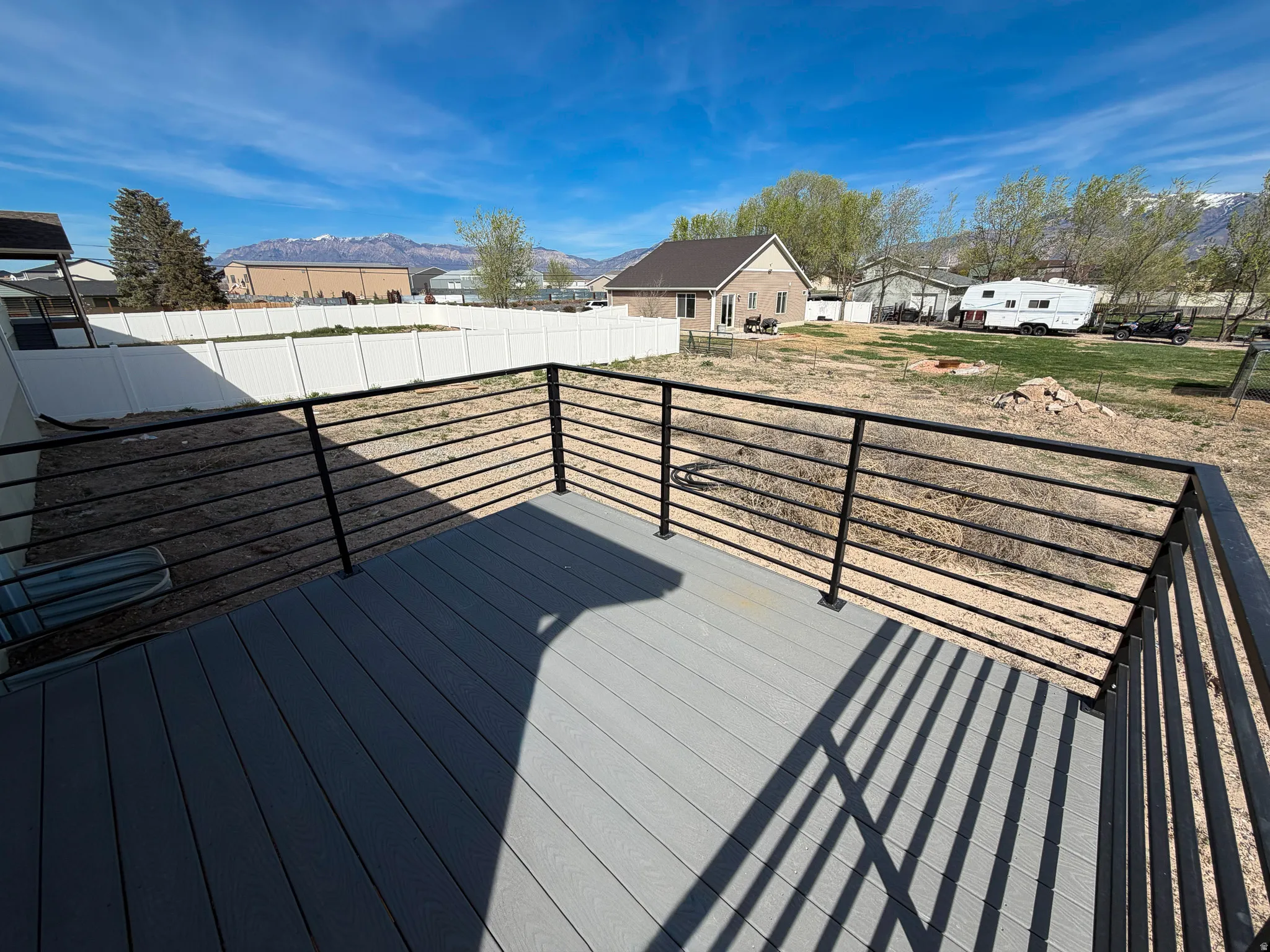 Deck with a mountain view, a residential view, and a fenced backyard