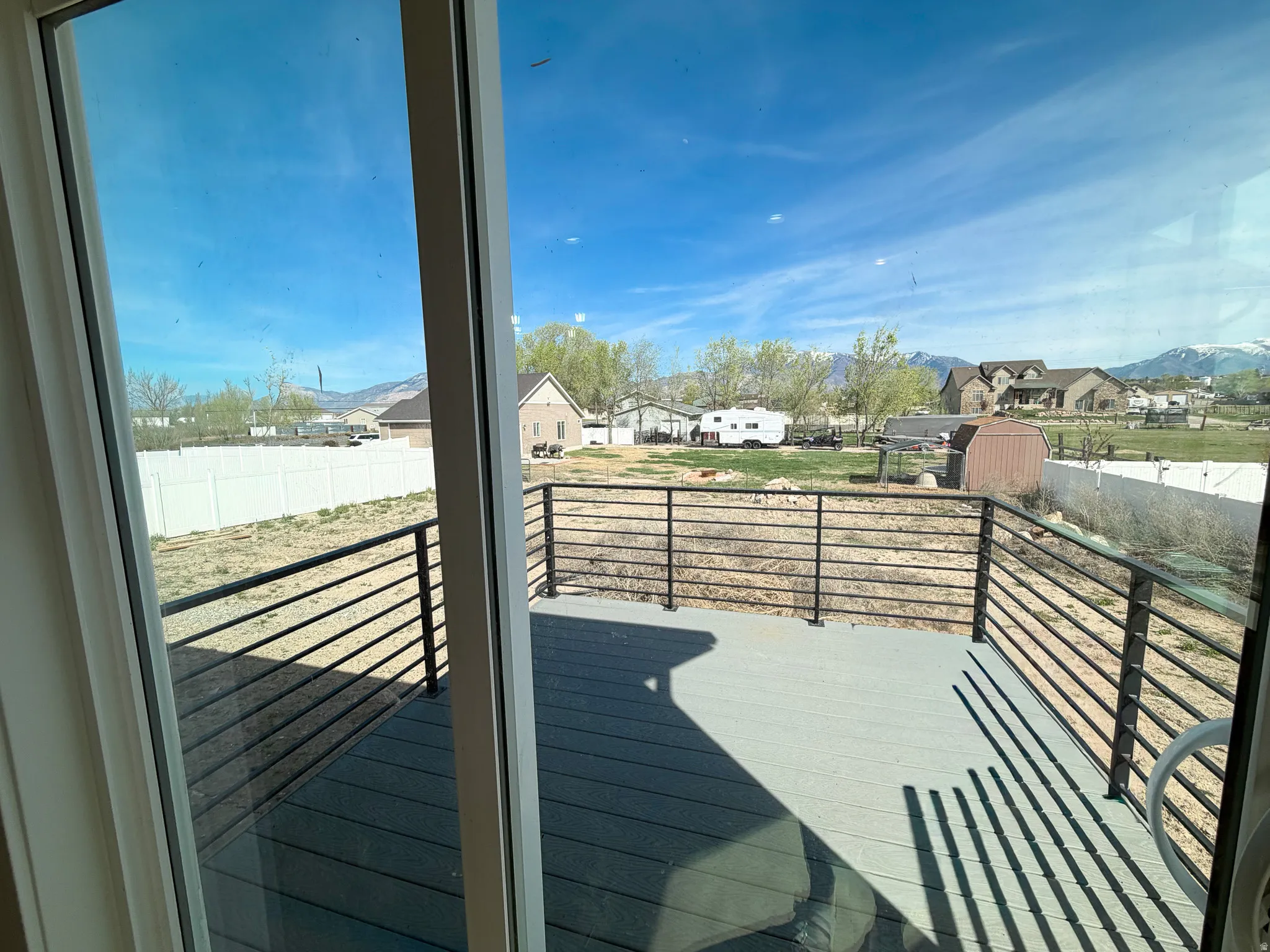 Wooden terrace with a residential view and a storage shed