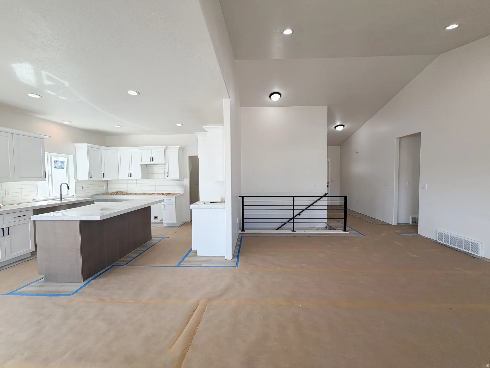 Two tone kitchen featuring a kitchen island, tasteful backsplash, a breakfast bar, open floor plan, and recessed lighting