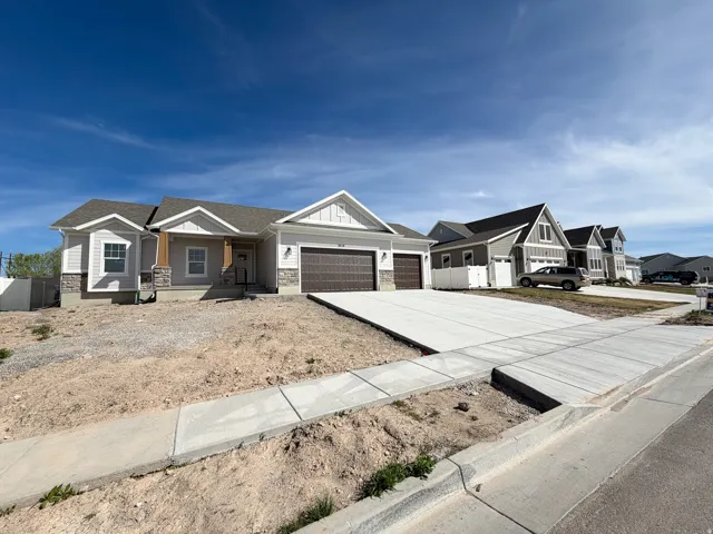 View of front of house featuring a garage, covered porch, concrete driveway, a residential view, and board and batten siding