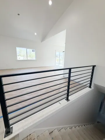 Stairway with recessed lighting, a high ceiling, and wood finished floors