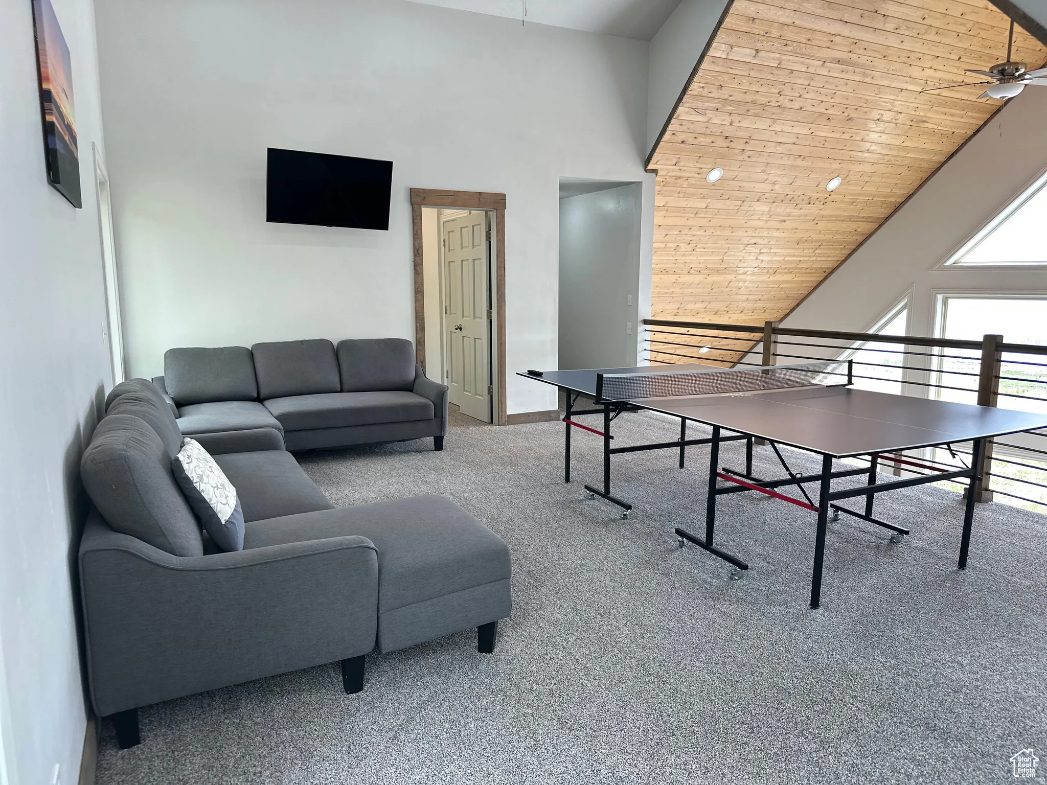 Game room with a ceiling fan and a vaulted wood ceiling