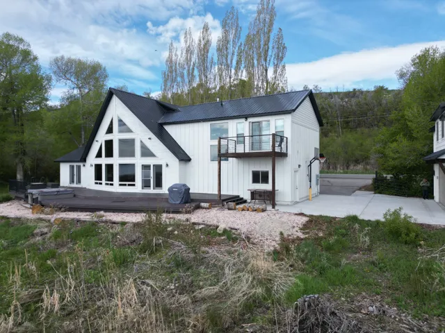 Rear view of house with a metal roof and a deck