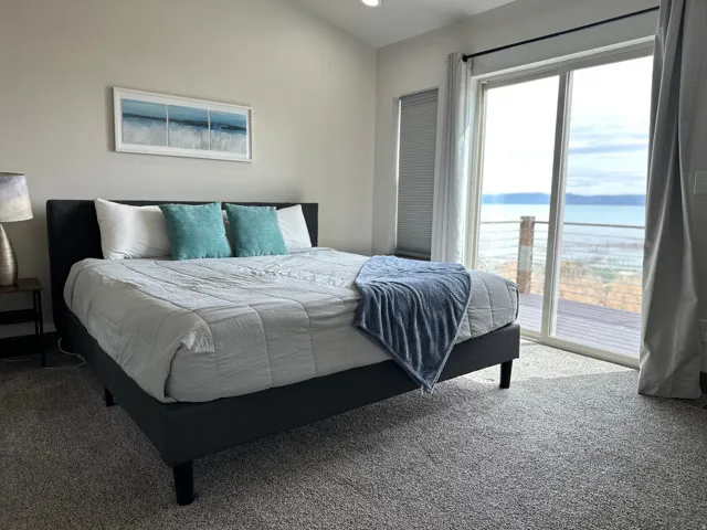 Carpeted bedroom featuring access to outside and a water view
