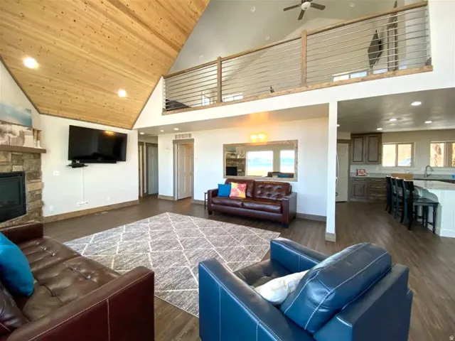 Living room featuring a fireplace, recessed lighting, dark wood-style flooring, ceiling fan, and plenty of natural light