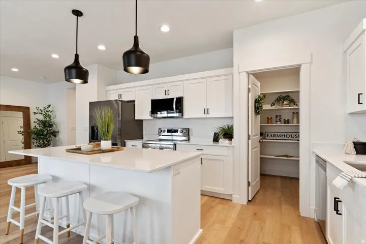 Kitchen with white cabinetry, a breakfast bar area, and stainless steel appliances