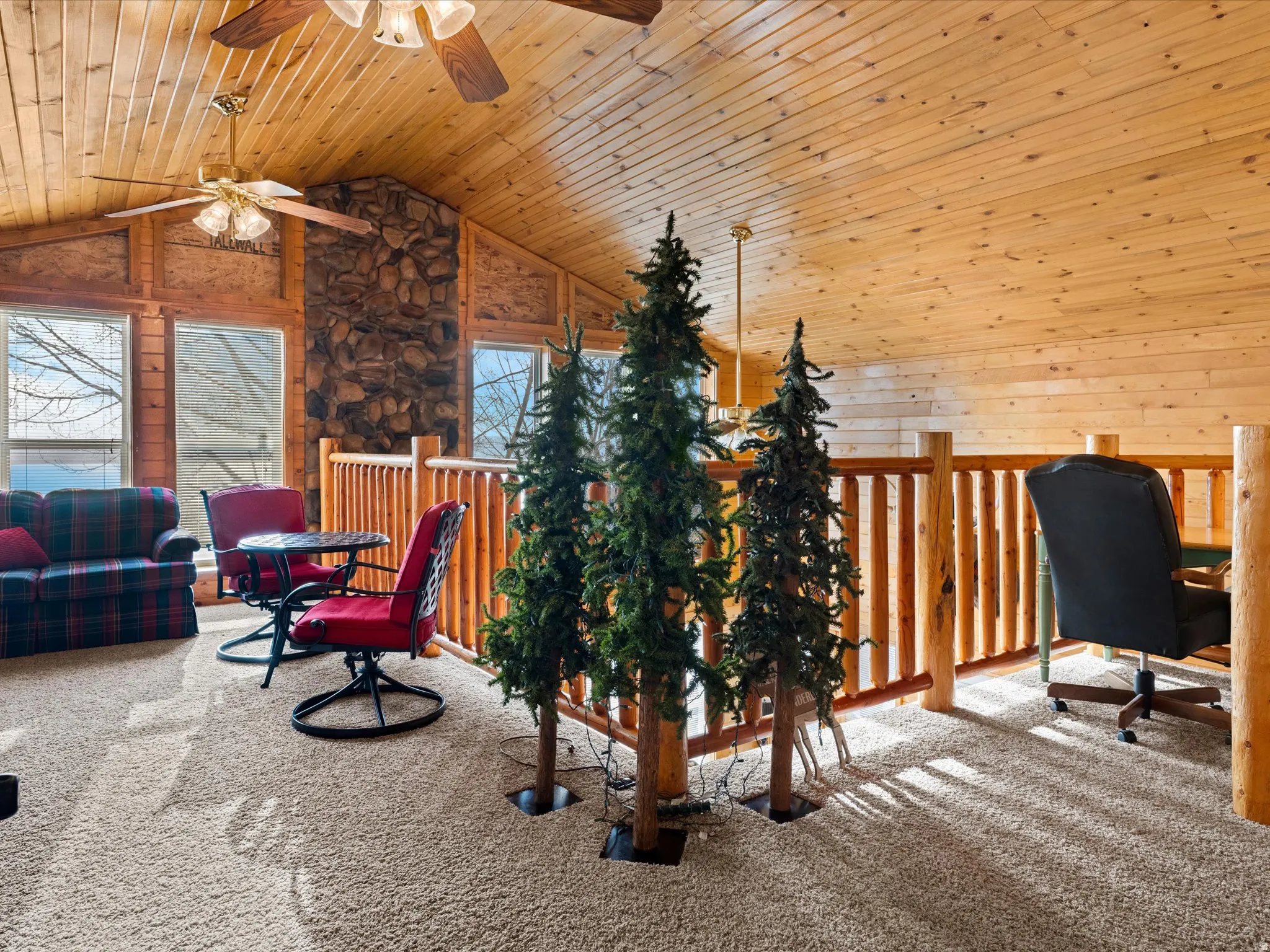 Home office with light colored carpet, a ceiling fan, a high wood ceiling, and wooden walls