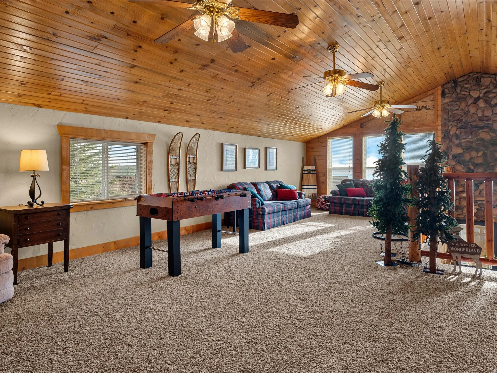 Recreation room featuring light carpet, ceiling fan, and a vaulted wooden ceiling
