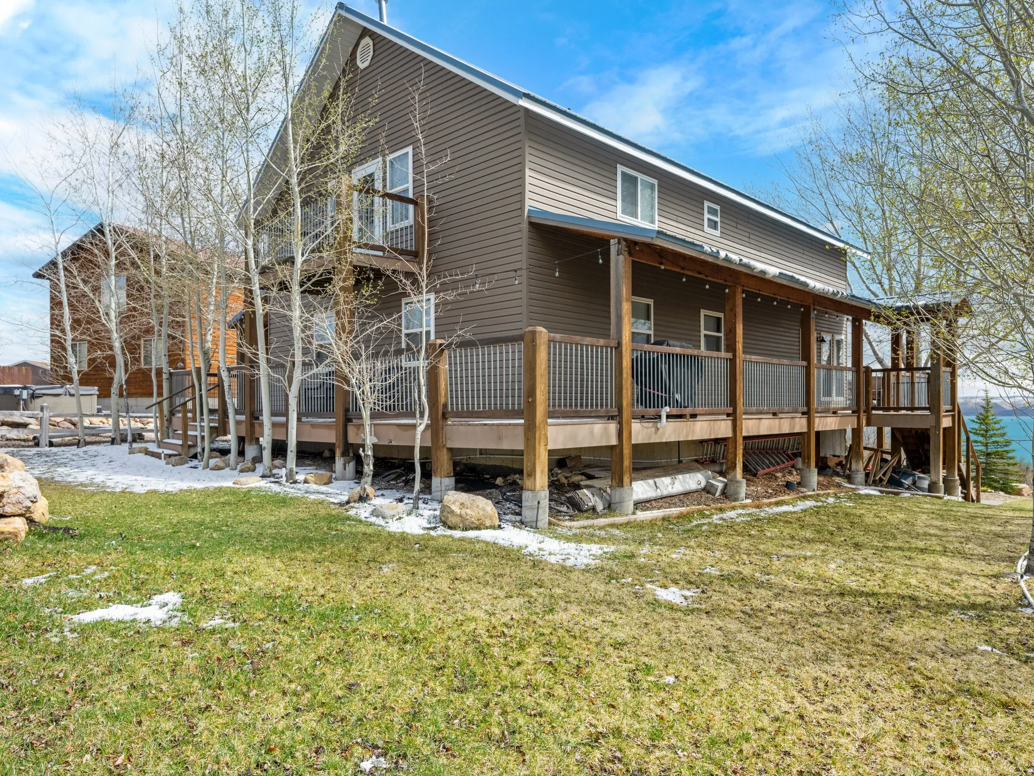 Rear view of house featuring a lawn and covered porch